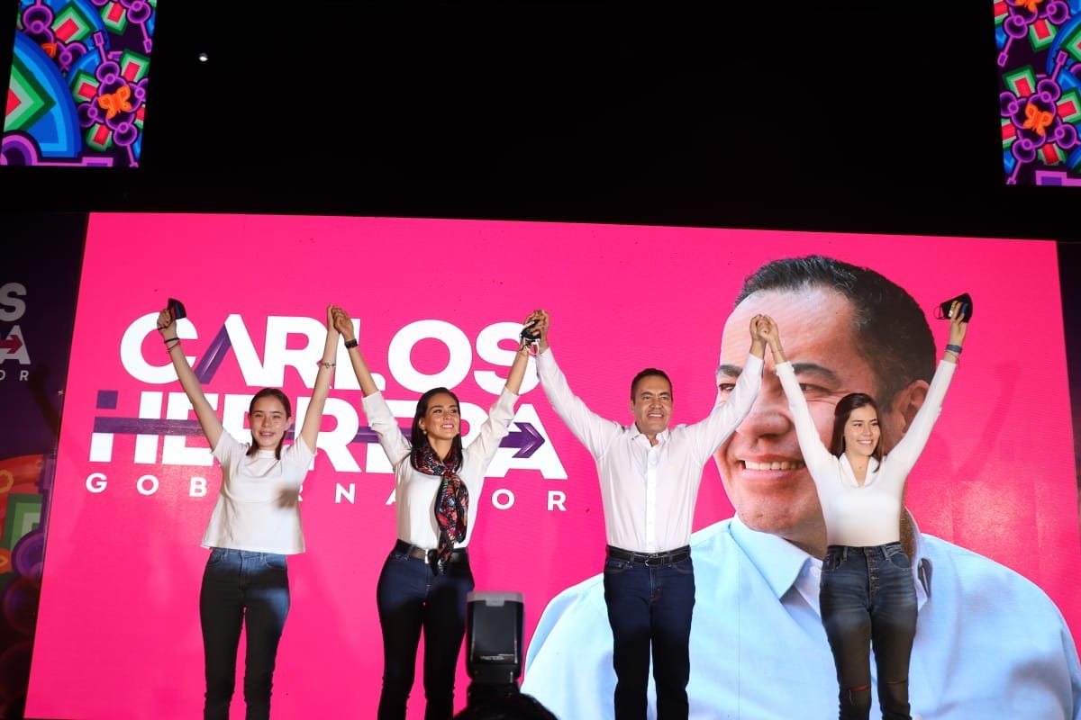 Candidato del PRIANRD Carlos Herrera con tres mujeres guapas levantando las manos en señal de victoria