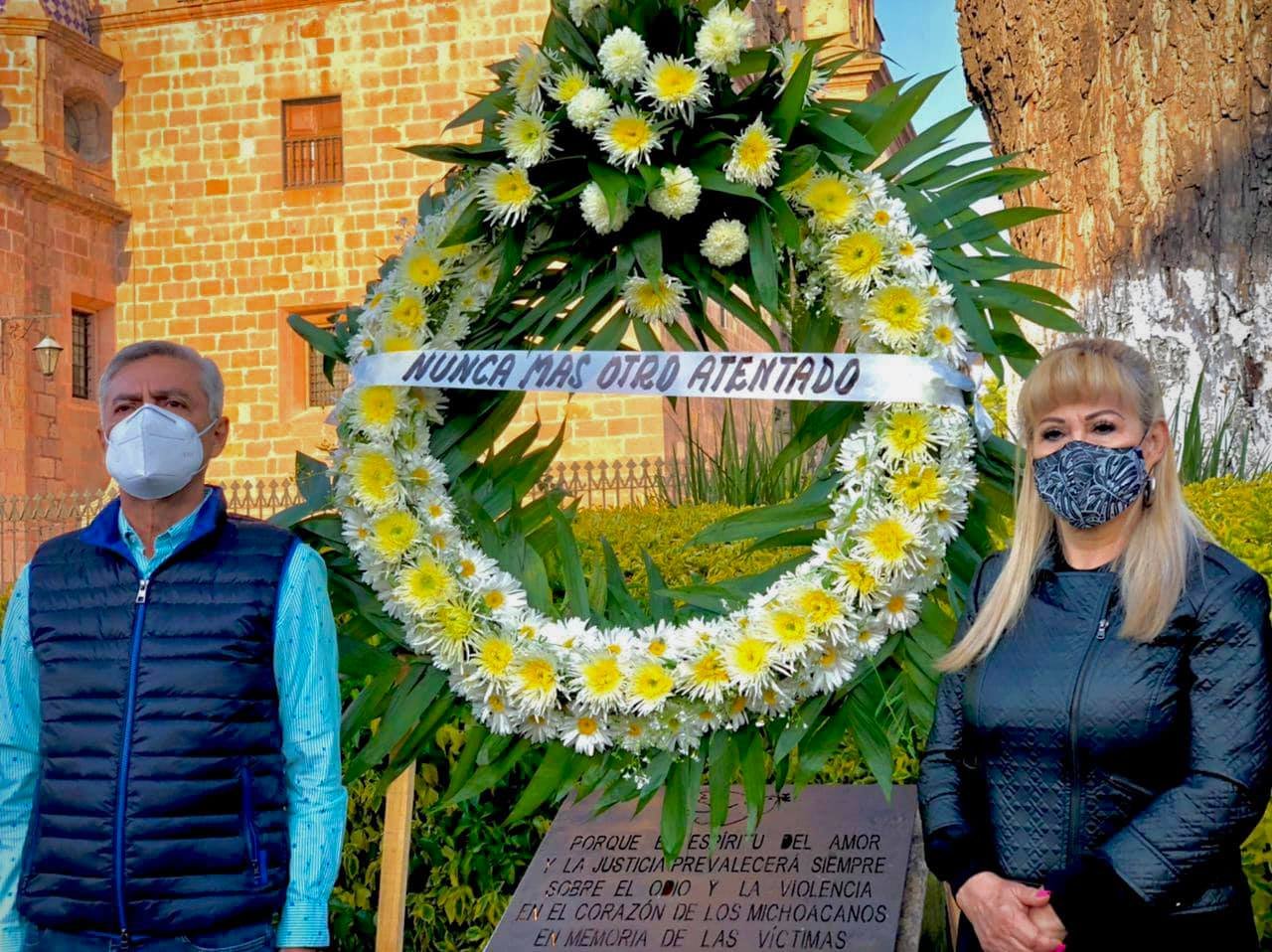 Cristobal Arias posa con una corona de flores en la placa conmemorativa del atentado del 2008 en la plaza Melchor Ocampo de Morelia