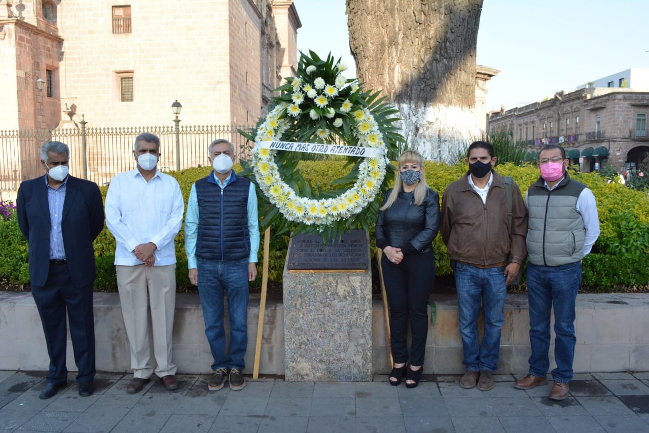 Cristóbal Arias posa para fotografía en placa conmemorativa del atentado de hace 13 años en la celebración de la independencia en Morelia