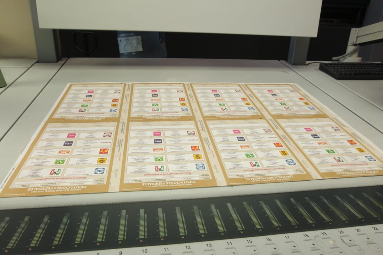 8 boletas del INE saliendo de un pliego impreso