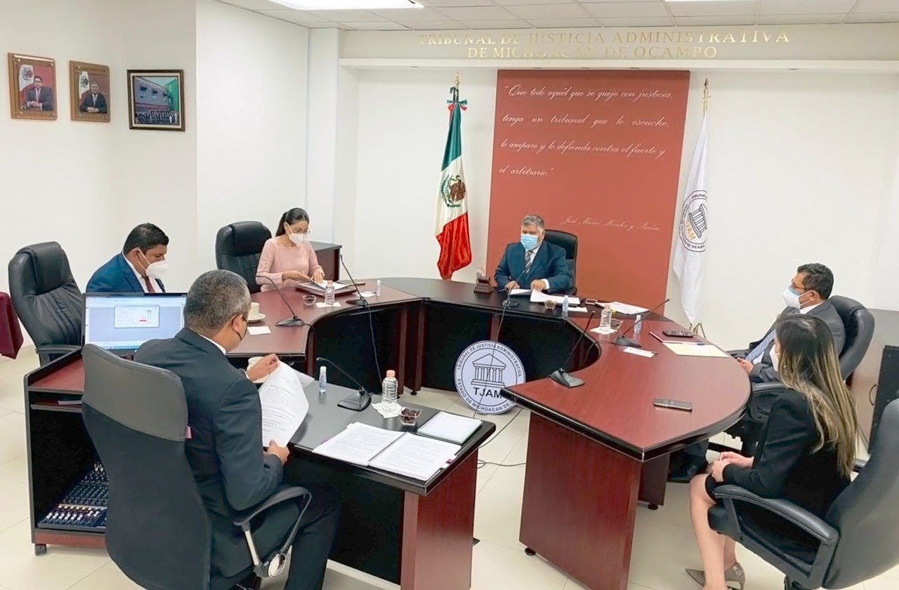 Jesus sierra en una mesa en forma de herradura con otros 5 miembros del tribunal