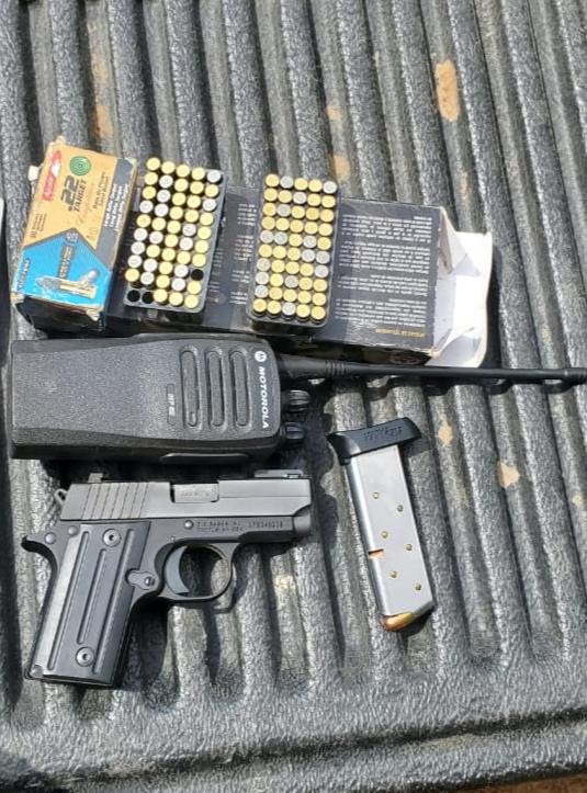 Pistola escuadra pequeña un cargador y dos cajas de balas, también un radio motorola negro