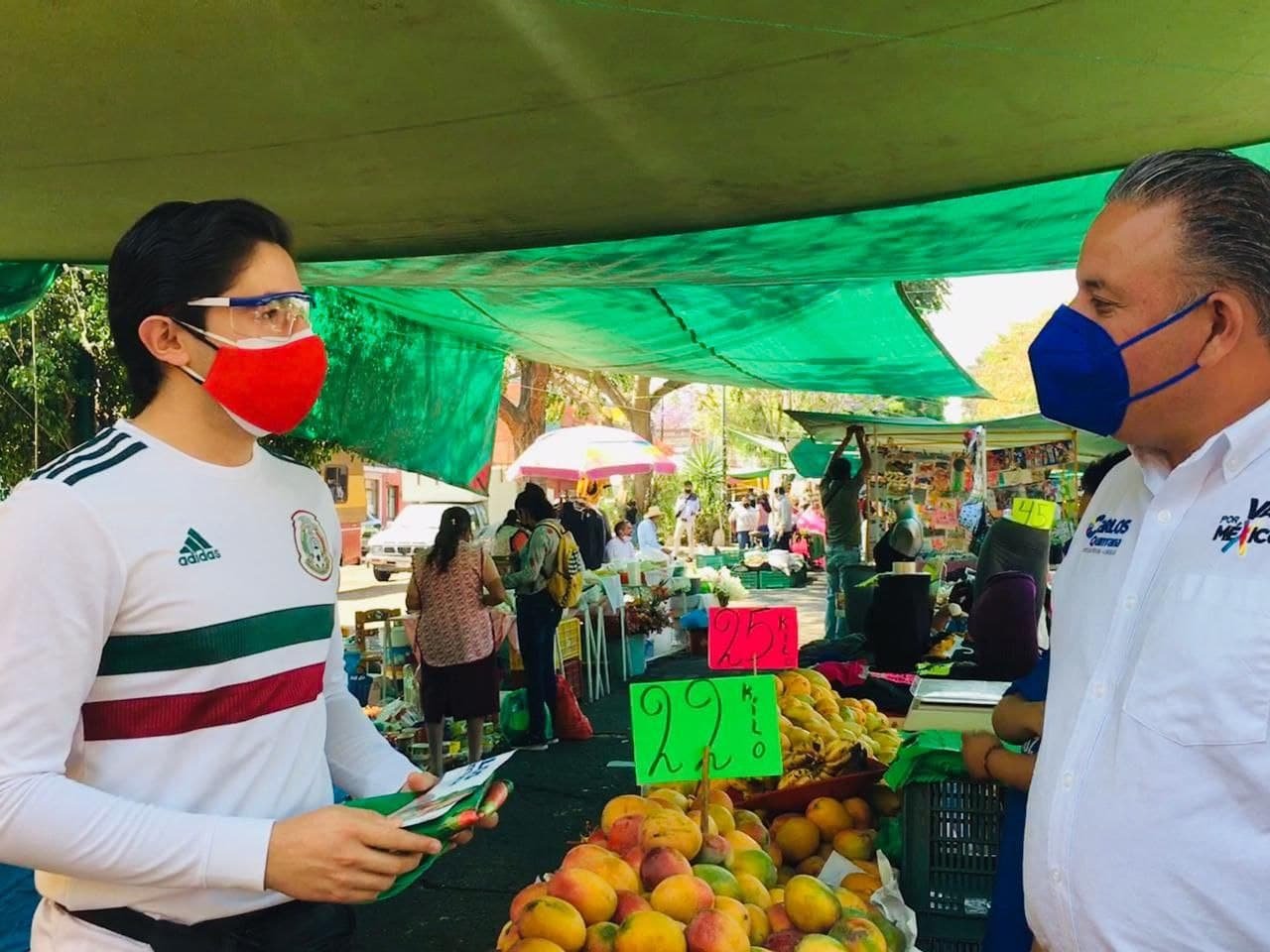 El candidato Carlos Quintana del PRIANRDconversa en un mercado con un joven de apariencia Whitexican