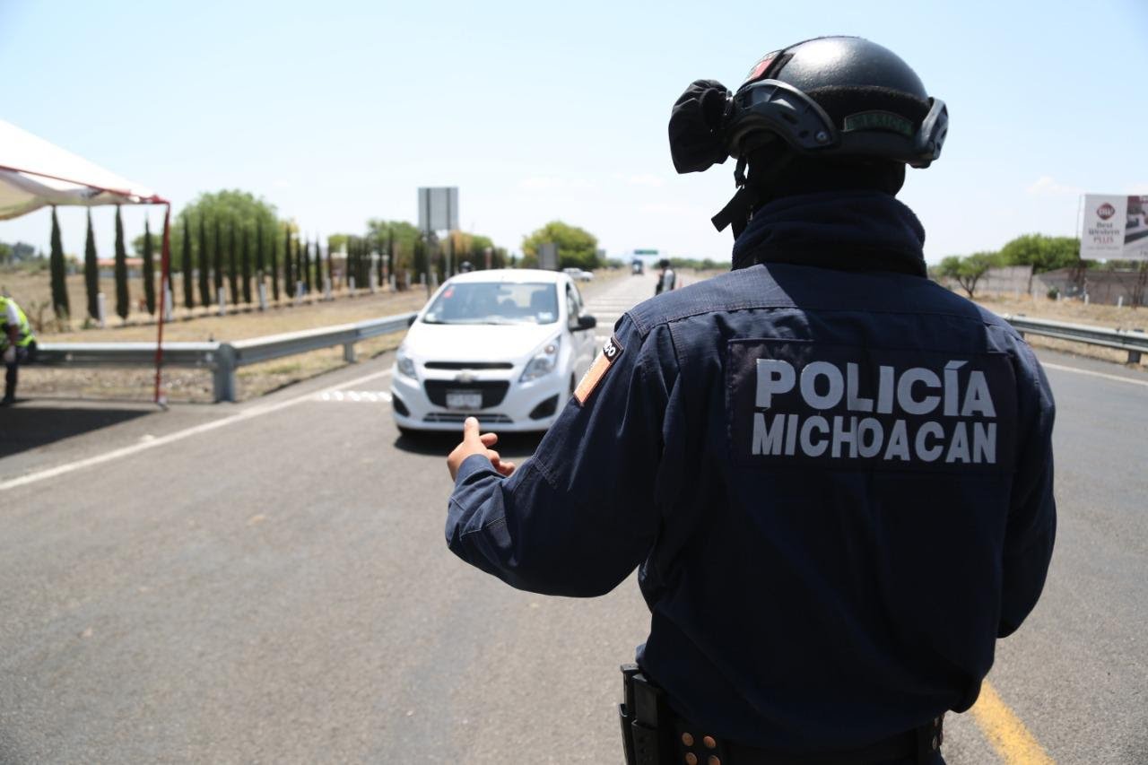 policía señalando a automovilista que se detenga en un retén anticonstitucional de la policía michoacán
