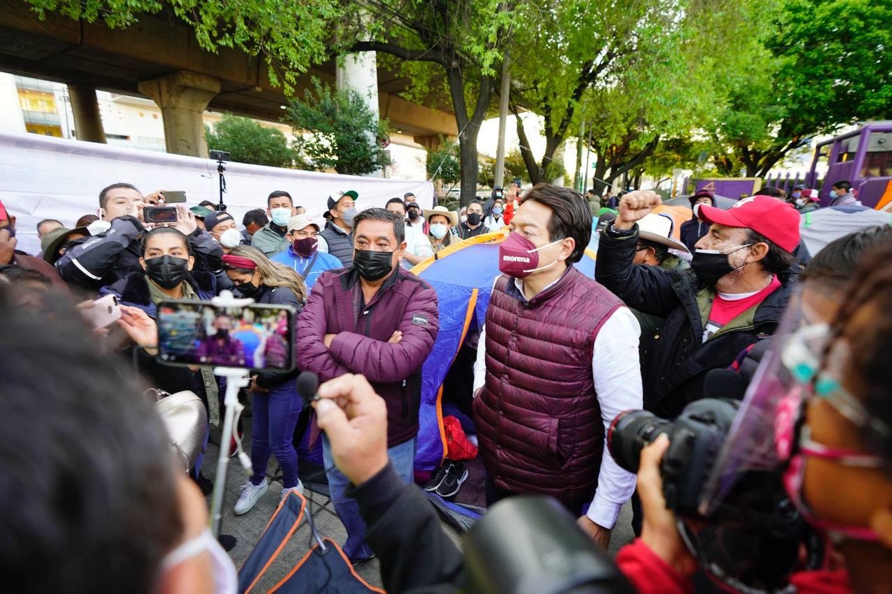 Felix salgado macedonio y mario delgado entre una multitud afuera del edificio del ine