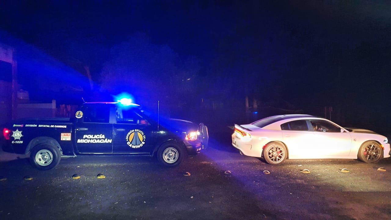 vehiculo dodge blanco deportivo y detrás una patrulla de caminos estatal