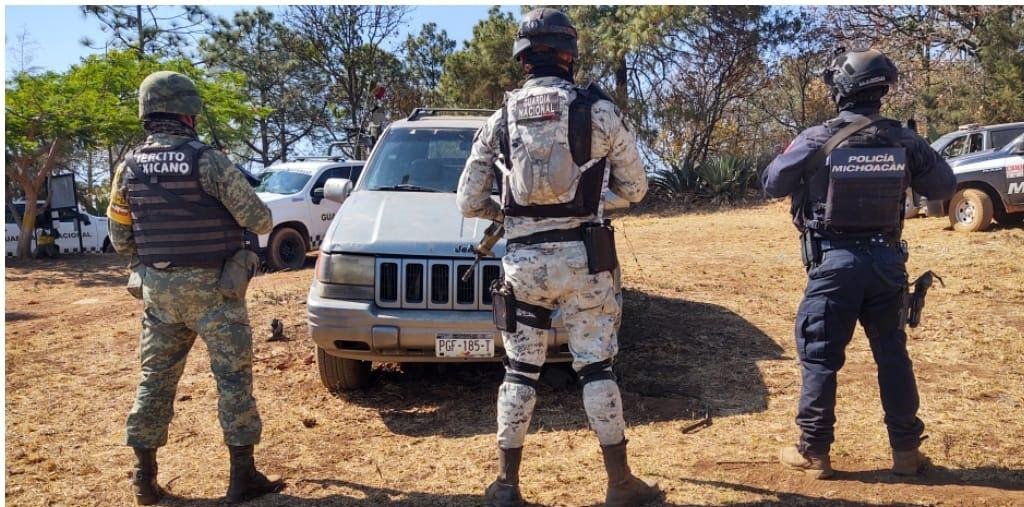 tres miembros de seguridad, militar, guardia nacional y policia custodian una camioneta jeep cherokee