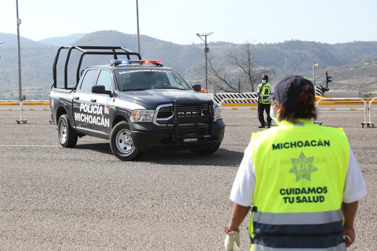 patrulla al fondo policia de espaldas en primer plano