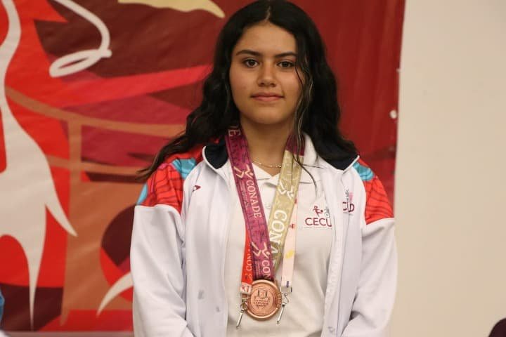 Joven atleta posa con medalla puesta