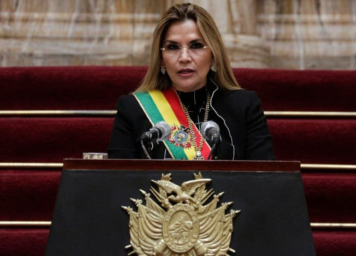 Jeanine añez luciendo la banda presidencial en un discurso